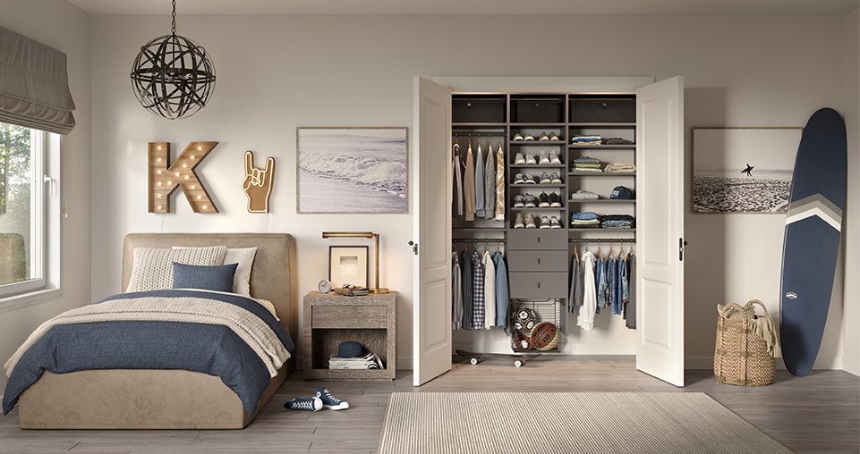 Grey reach in closet with drawers and shelving shown in a bedroom with a surfboard to the right.